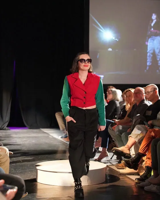 Model in a red and green color-block blazer on the runway