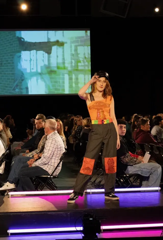 Model in an orange and green carnival-inspired outfit