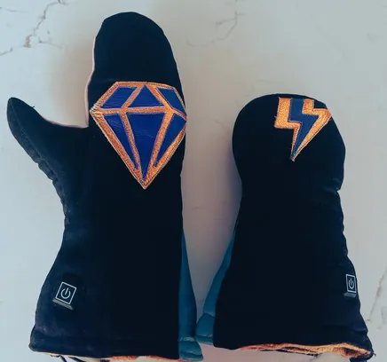Kimber Cross's finished glove set: navy mitts with an orange diamond and lightning-bolt appliqué