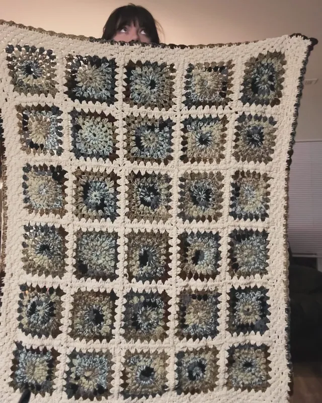 Blue and cream granny-square blanket held up