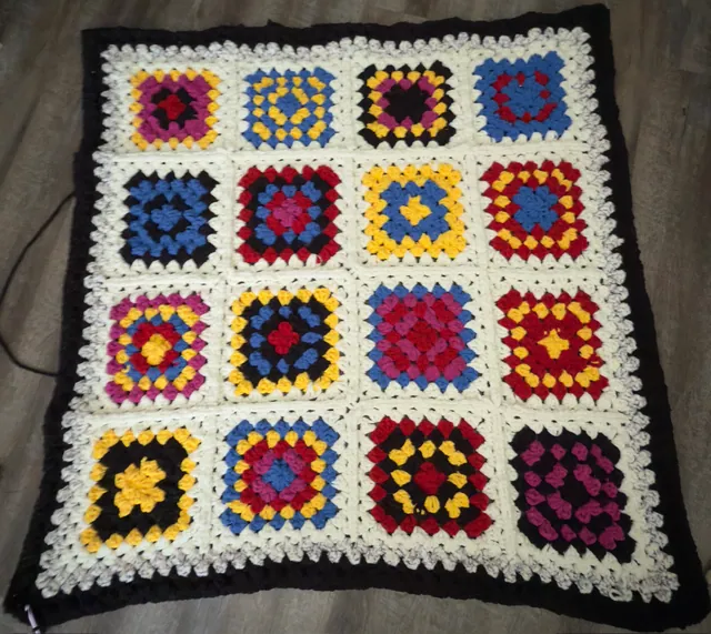 Granny-square blanket in primary colors with a black border